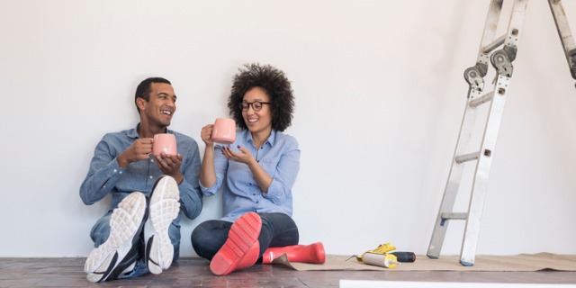 Young couple taking a break from painting their fixer-upper